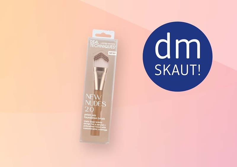 Balenie make-up štetca Real Techniques New Nudes 2.0 v plastovom blistri s viditeľným zlatavým držadlom a štetinkami na svetloružovom až lososovom pozadí, vpravo modrý kruh s bielym nápisom dm SKAUT!
