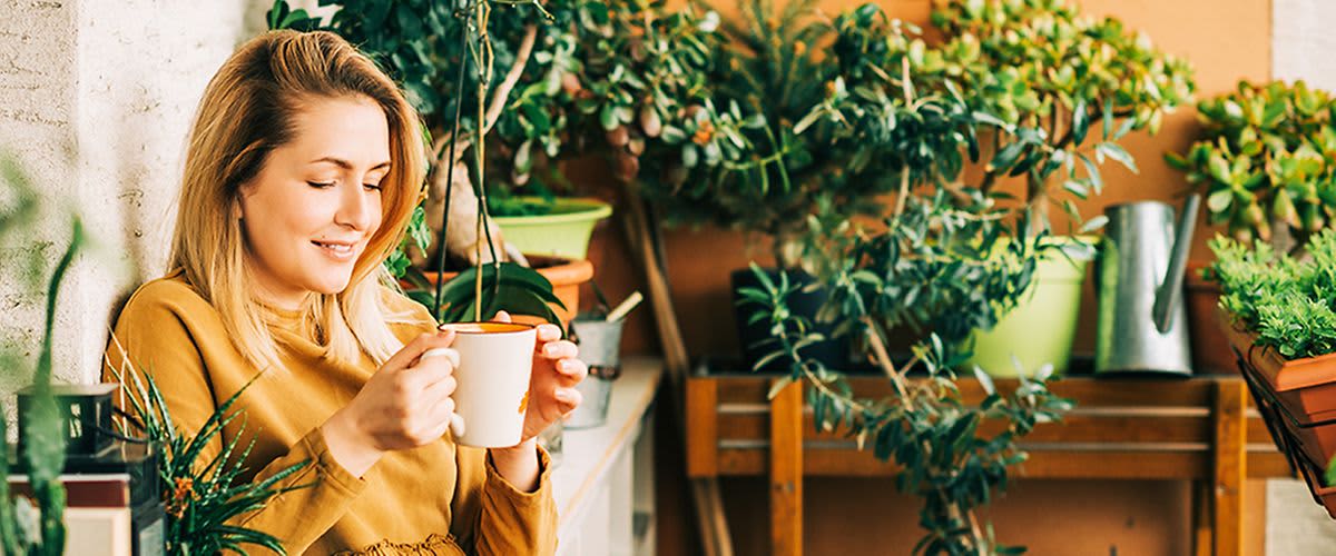 Žena na balkóne so šálkou čaju