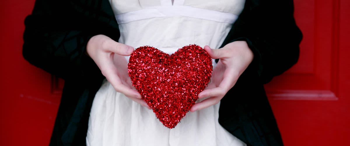 Žena drží v rukách vlentínske srdce.