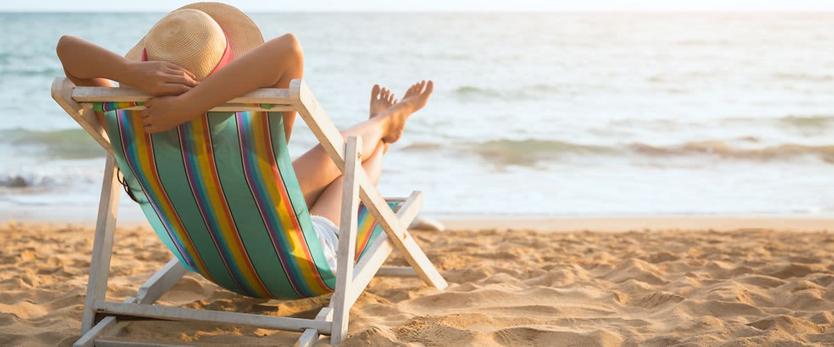 žena na pláži na lehátku
