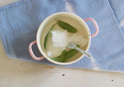 Lístky šalvie s kokosovým olejom v hrnci.