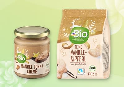 Sklenená nádoba s mandľovo-tonkovým krémom a balenie vanilkových rožkov na zelenom pozadí.