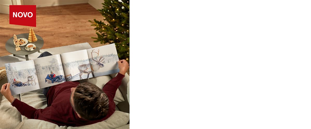 Moški bere knjigo o severnem jelenu ob božičnem drevesu