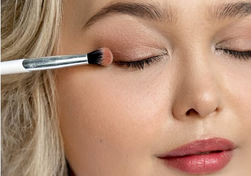 Frau trägt Lidschatten auf