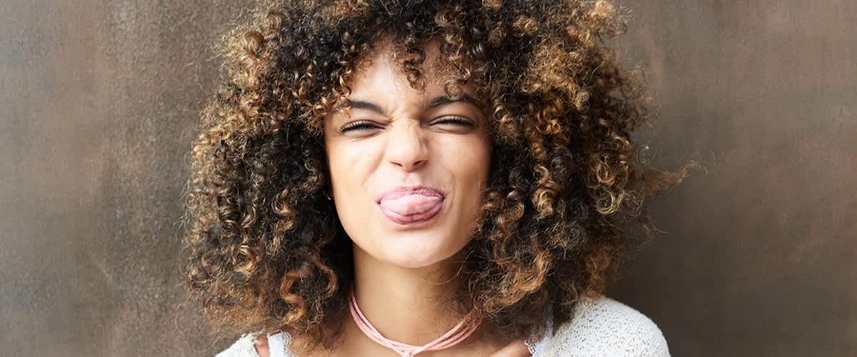 Oseba z rjavimi in svetlimi kodrastimi lasmi