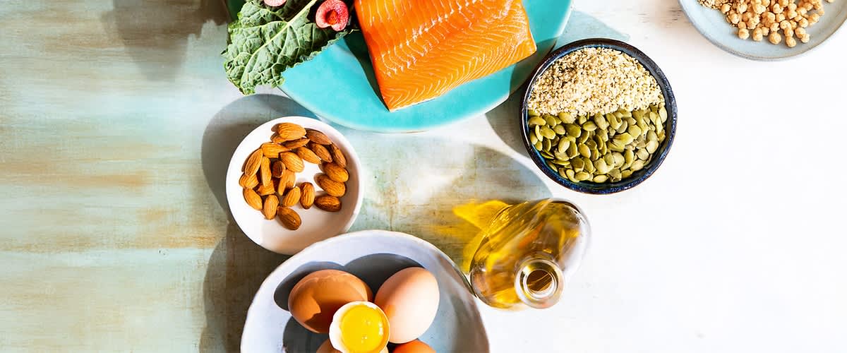 Zdrava hrana z lososom, jajci, mandlji, olivnim oljem in semeni