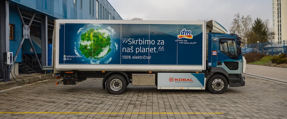 Landschaftsaufnahme eines Flusses zwischen grünen Hügeln.