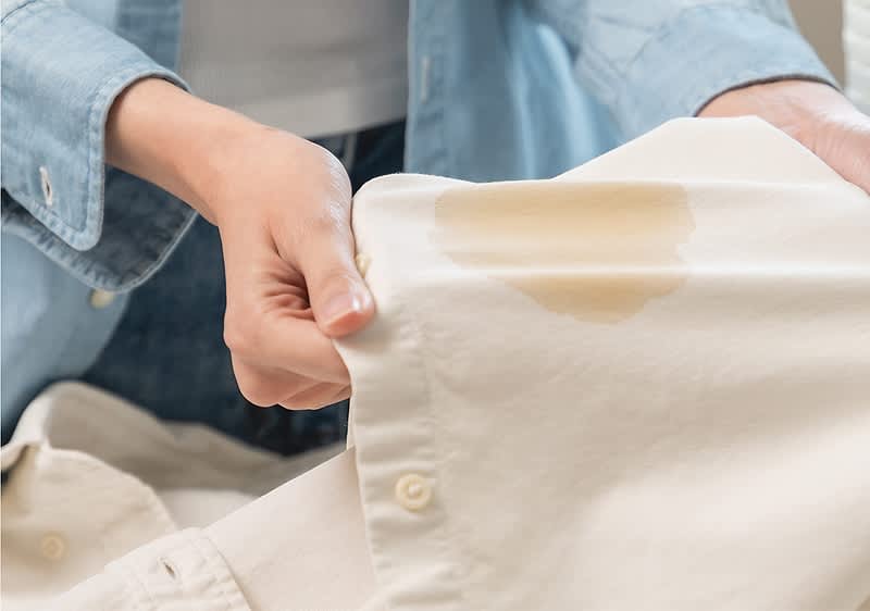 Madež na beli srajci v bližini košare za perilo