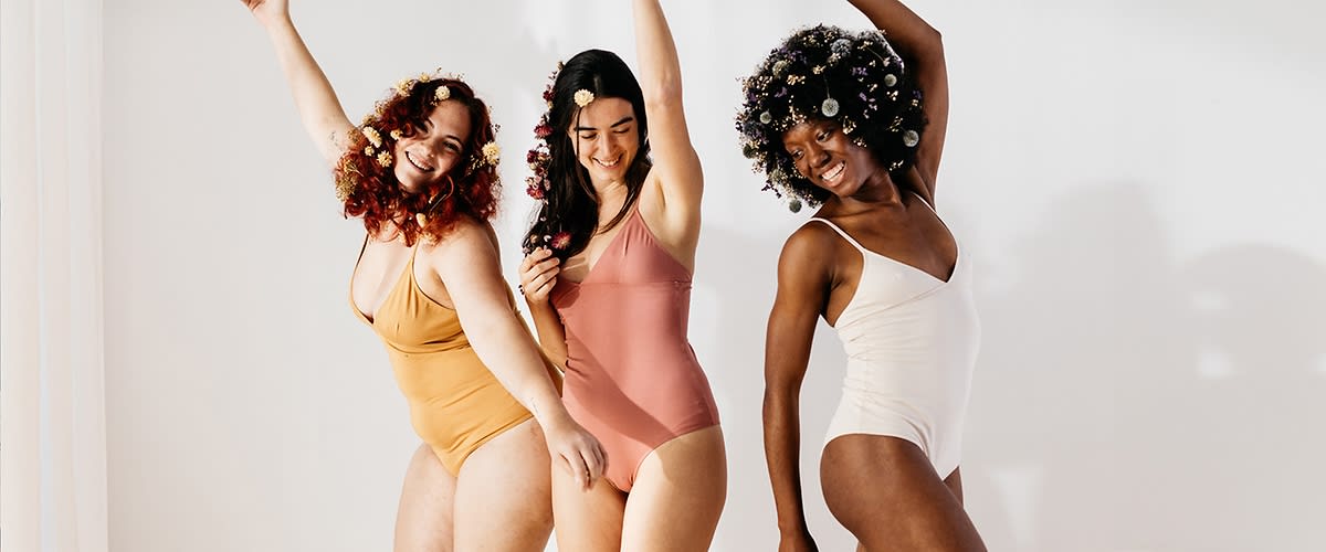 Ženske v kopalkah s cvetličnimi pričeskami pozirajo v studiu.