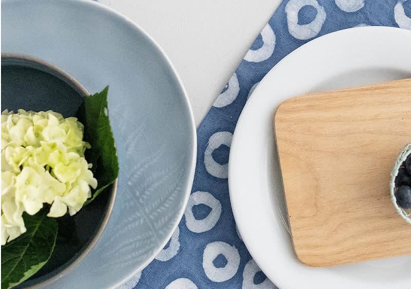 Modra miza s krožnikom, cvetom hortenzije in leseno desko
