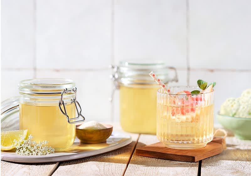 Bezgov sirup v kozarcih in pijača z bezgovim sirupom ter limono