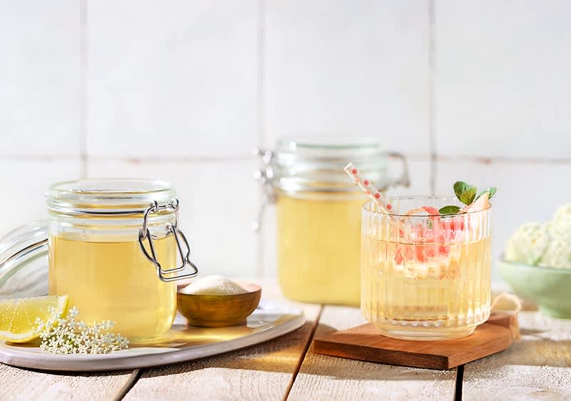 Bezgov sirup v kozarcih in pijača z bezgovim sirupom ter limono