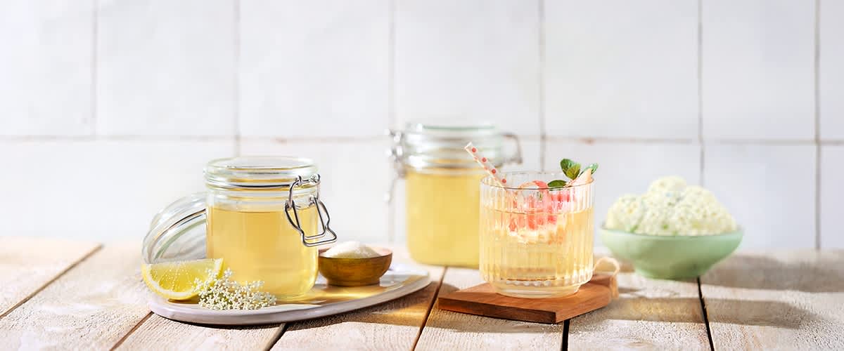 Bezgov sirup v kozarcih in pijača z bezgovim sirupom ter limono
