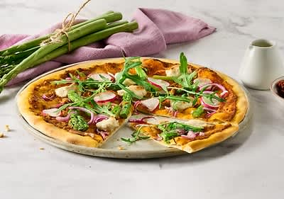 Pizza z beluši, rukolo in rdečo čebulo na marmornati površini