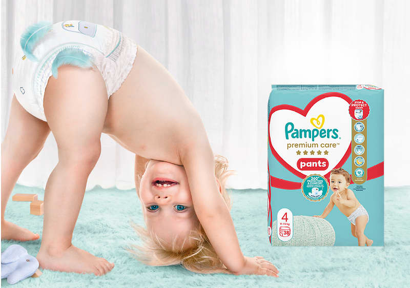 Alt-Text Dojenček v plenicah Pampers se igra na mehki preprogi