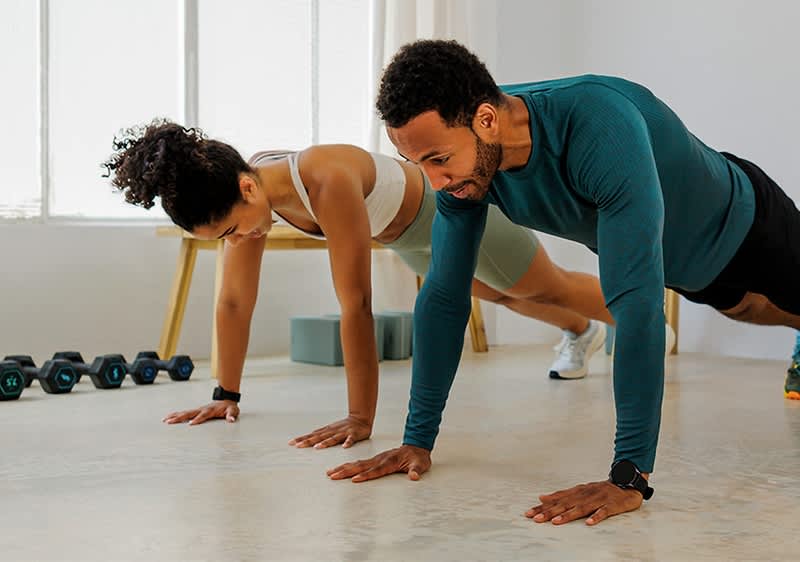 Alt-Text: Vadba v paru z utežmi in joga bloki v ozadju