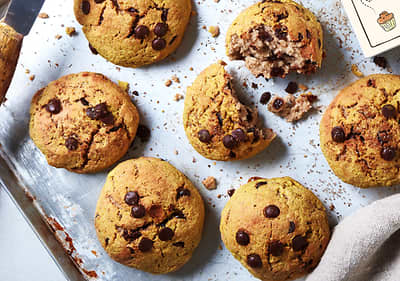 Piškoti s čokoladnimi koščki na pekaču, eden je delno zlomljen