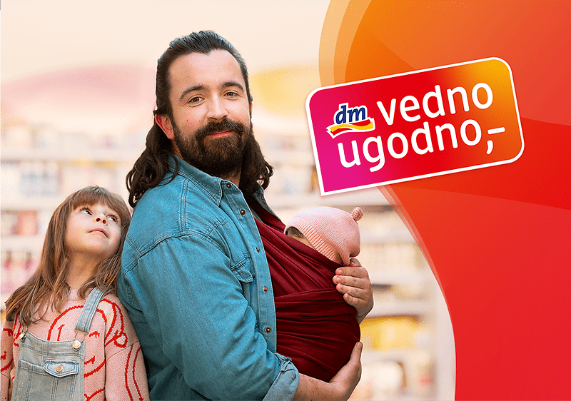 Vedno ugodno dm logotip na rdečem ozadju z napisom Vedno več za vaš denar