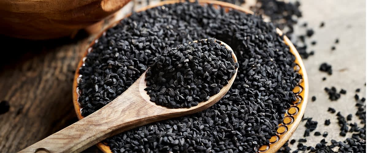 Alt-Text Lesena žlica polna črnih semen na krožniku