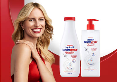 Steklenička in pumpica Lactovit Lactourea repairing losjona pred rdečim ozadjem