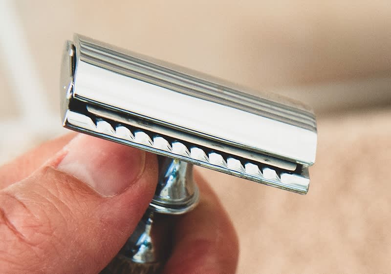 Alt-Text Ročna britvica z kovinskim rezilom v roki