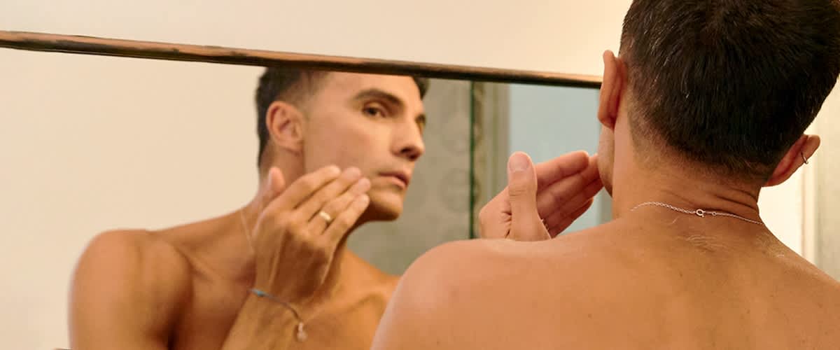 Moški pred ogledalom z zapestnico na roki