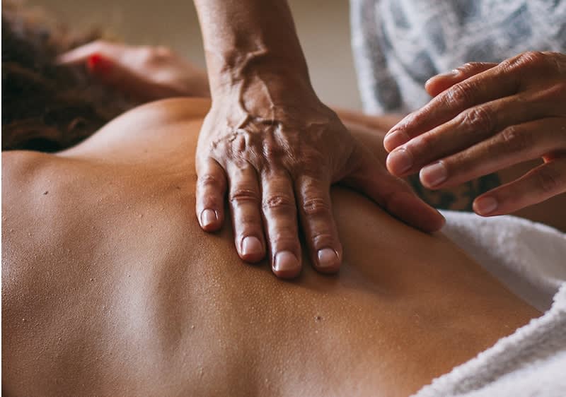 Alt-Text Masaža hrbta z rokami na koži