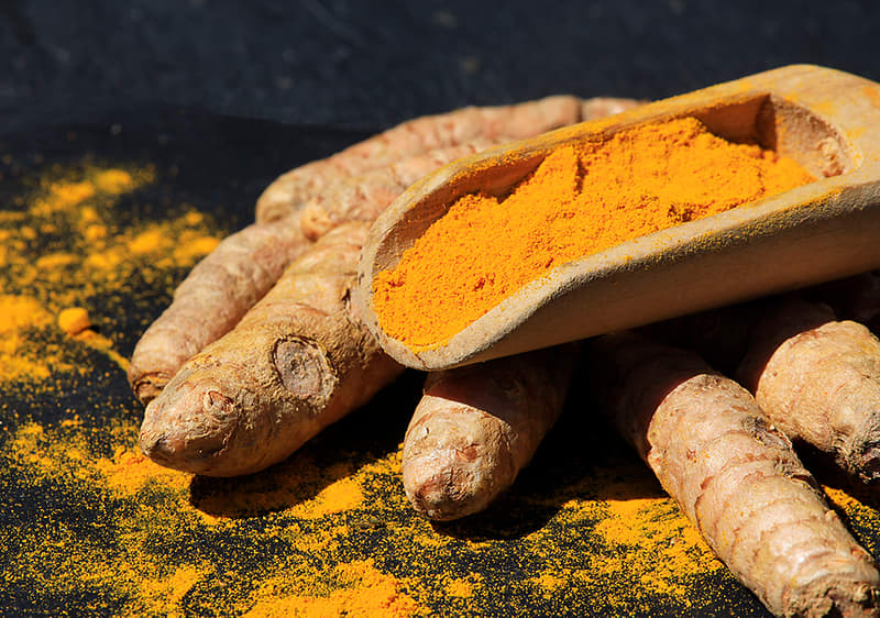 Alt-Text Kurkuma v prahu na korenikah kurkume