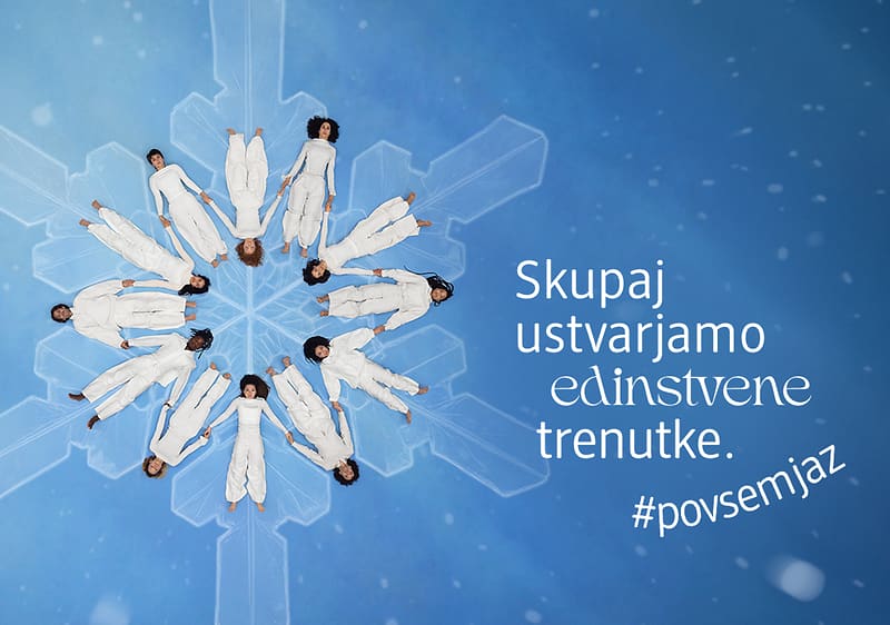 Alt-Text Snežinka z ljudmi v belih oblačilih in napisom 'Skupaj ustvarjamo edinstvene trenutke'