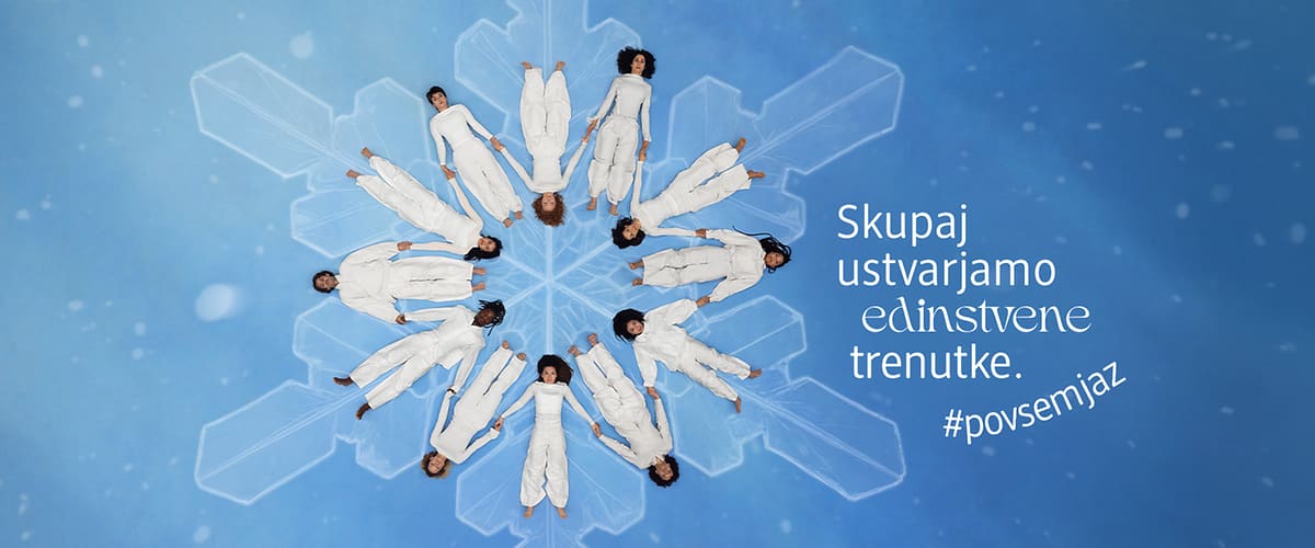 Alt-Text Snežinka z ljudmi v belih oblačilih in napisom 'Skupaj ustvarjamo edinstvene trenutke'