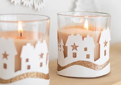 Alt-Text Sveče v steklenih kozarcih z zimskim motivom hiš