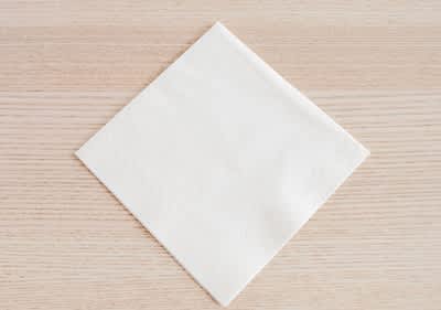 Alt-Text Bela papirnata servieta na leseni mizi