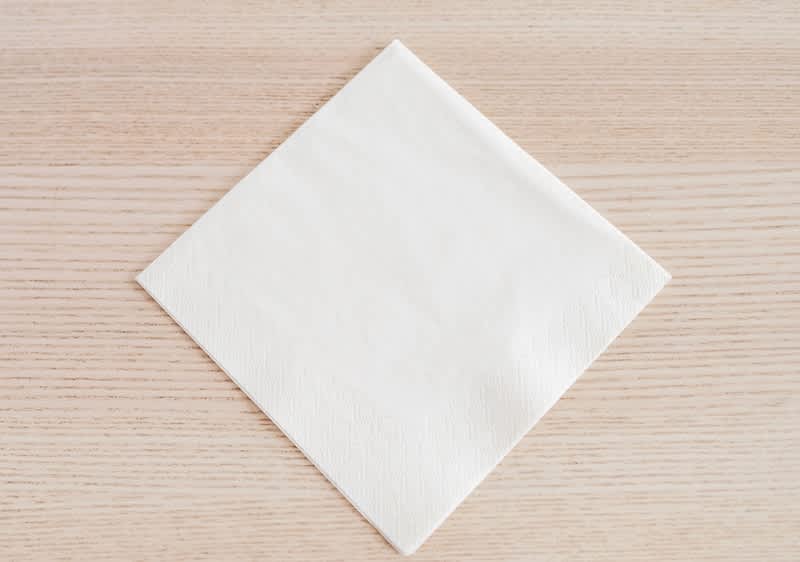 Alt-Text Bela papirnata servieta na leseni mizi