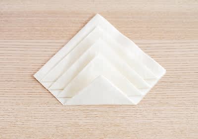 Alt-Text Zloženi prtički na leseni mizi