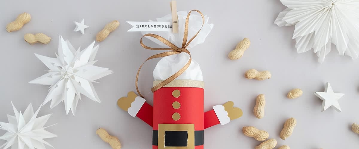 Alt-Text Božična dekoracija v obliki Božička z arašidi in papirnatimi zvezdami