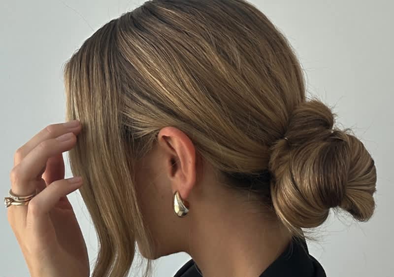 Alt-Text: Elegantna pričeska z nizko figo in svetlimi prameni