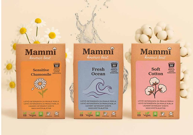 Alt-Text Tri škatle pralnega praška Mammi z motivi kamilice, oceana in bombaža