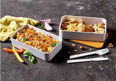 Alt-tekst: Dve posodi z obroki, ena z zelenjavno kvinojo, druga z oreščki in suhim sadjem.