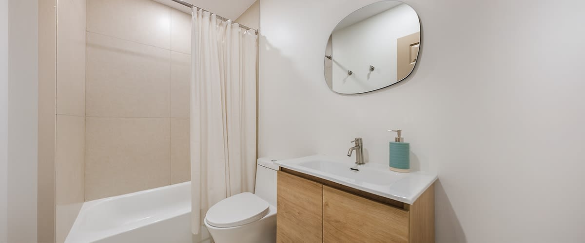 Moderna kopalnica z belo kadjo, prho, WC-jem in lesenim umivalniškim regalom