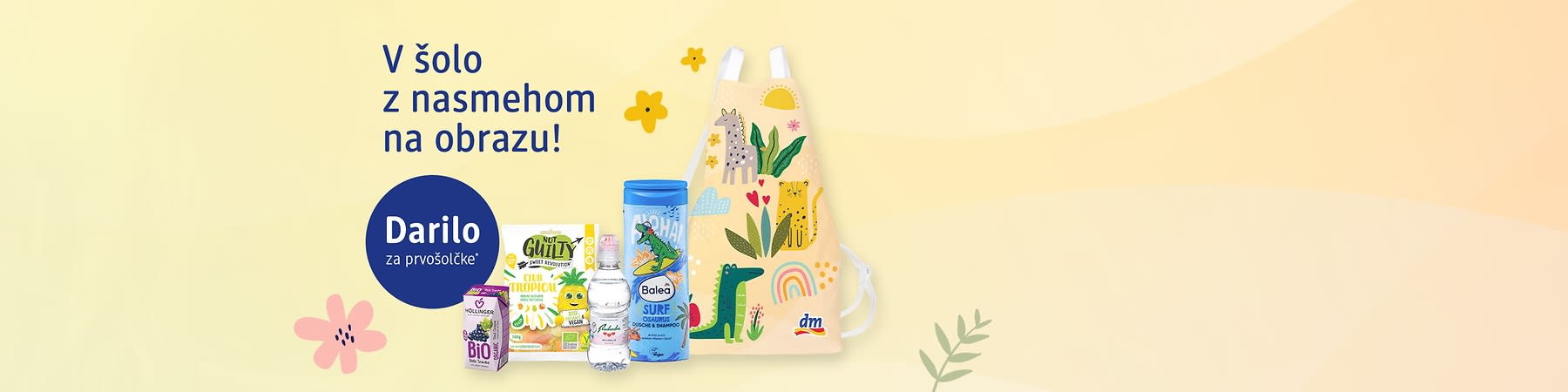 Darilo za prvošolčke s otroškim predpasnikom in različnimi pripomočki (pijača prigrizek šampon voda)