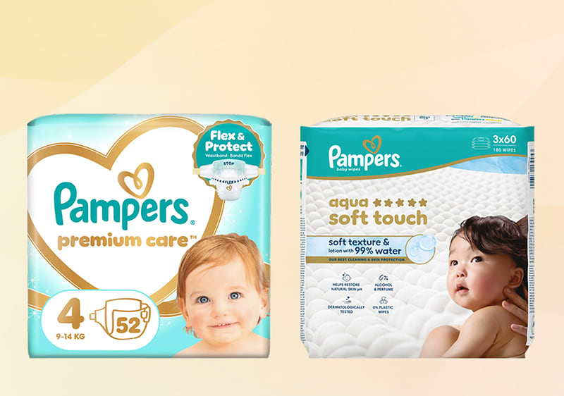 Dojenček v plenički leži na modrem ozadju in ob strani oglas z napisom Podarimo miren spanec, logotip Pampers, in besedilo o darilu plenic