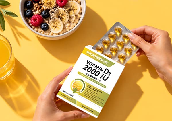 Slika koja prikazuje kutiju kapsula Vitamin D3 2000 IU pored zdrele sa voćem i čaše soka