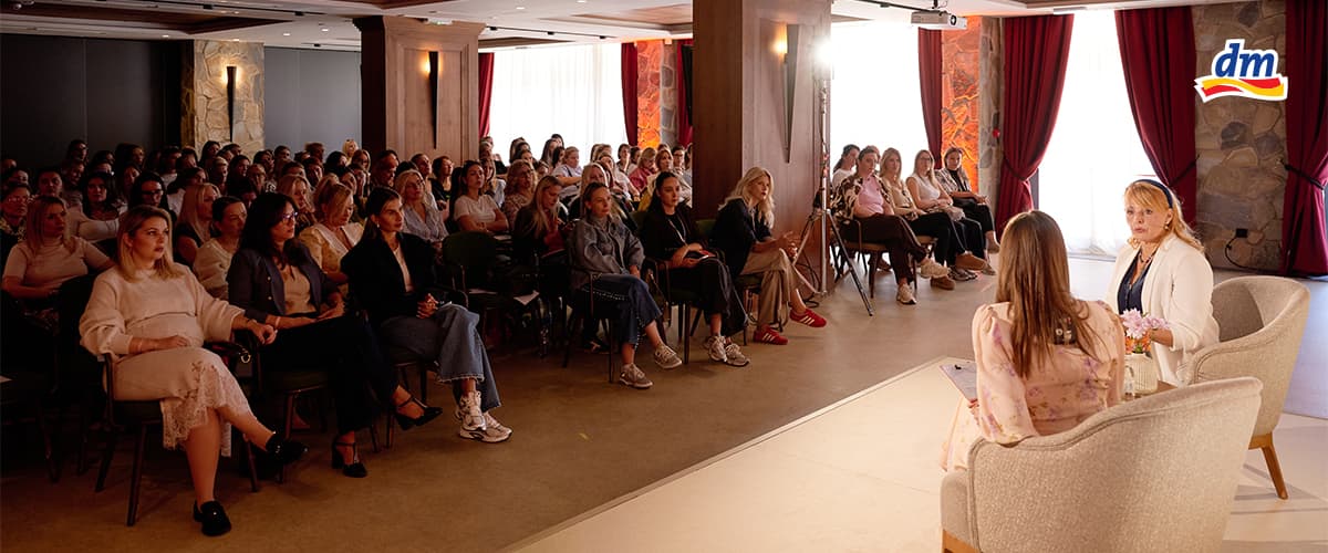 Slika koja prikazuje žensku panel diskusiju pred publikom u konferencijskoj sali