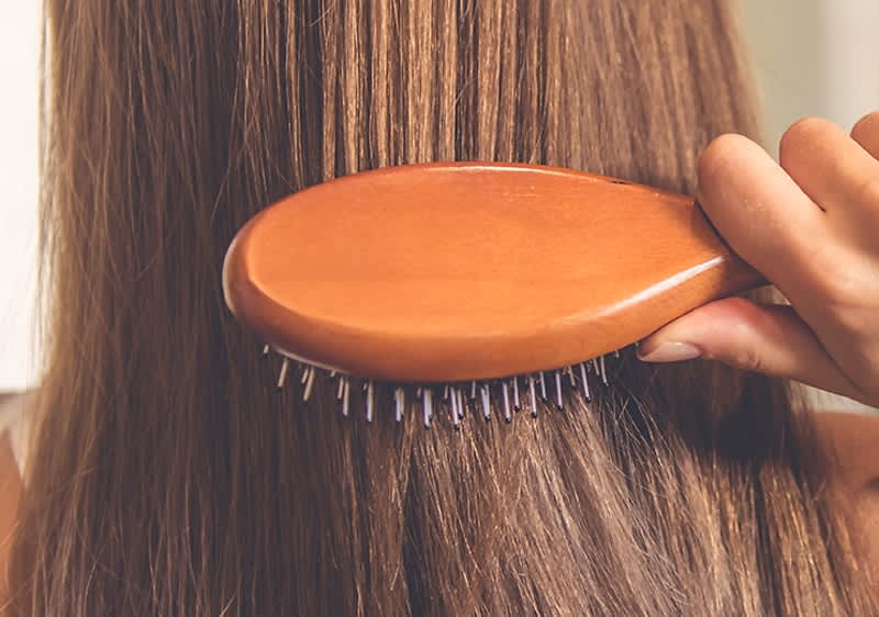 Frau bürstet ihre Haare