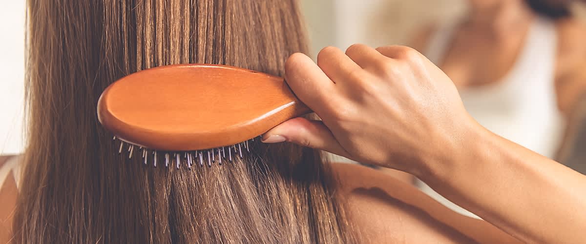 Frau bürstet ihre Haare