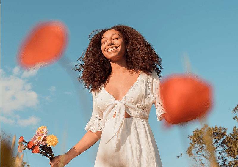 Frau schaut in den Himmel und lächelt