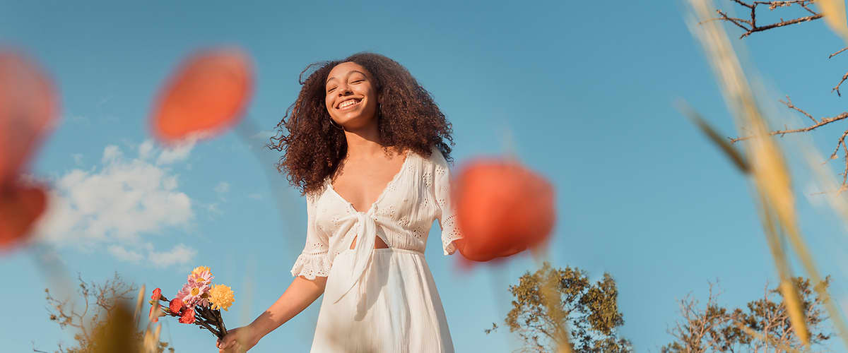 Frau schaut in den Himmel und lächelt