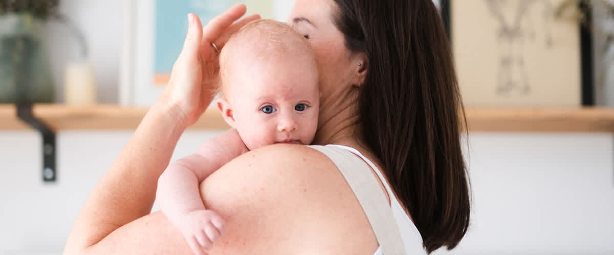 Baby schaut über die Schulter der Mutter