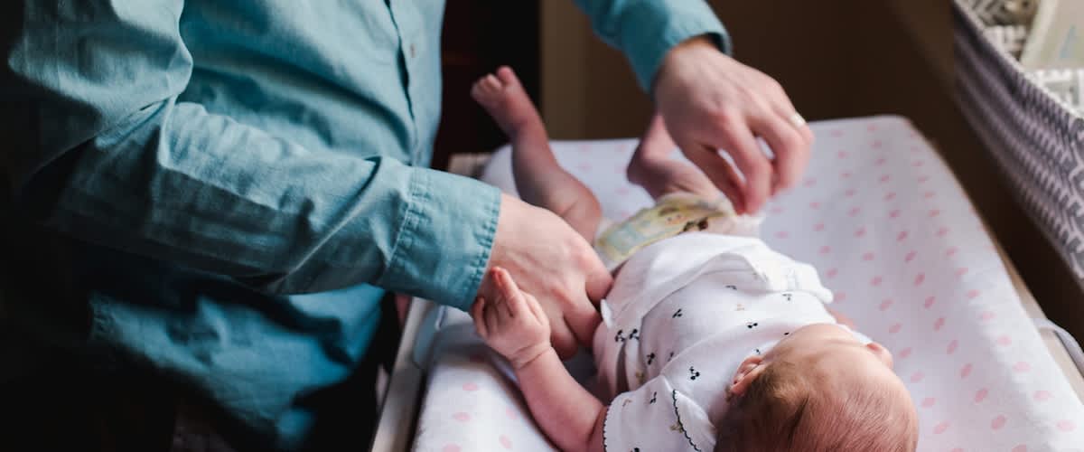Baby liegt auf Wicheltisch und Windel wird gewechselt