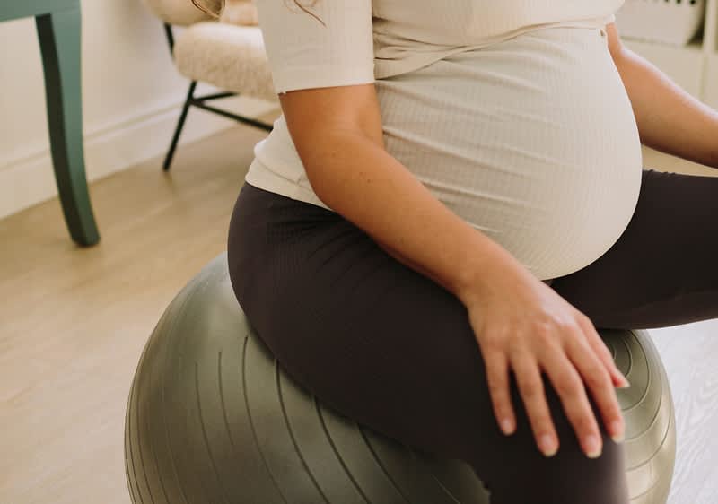 Schwangere Frau auf Gymnastikball